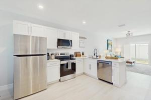 a kitchen with white cabinets and stainless steel appliances at Sunny Shores- Sunrise in Englewood