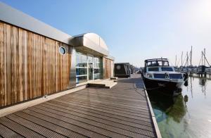 a boat parked on a dock next to a building at Glamping Houseboat in Dinteloord