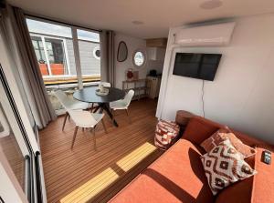 a living room with a couch and a table at Glamping Houseboat in Dinteloord