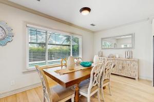 a dining room with a wooden table and chairs at The Sunshine Social in Naples
