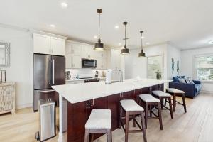 a kitchen with a large island with bar stools at The Sunshine Social in Naples +36 photos