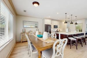 a kitchen and dining room with a wooden table and chairs at The Sunshine Social in Naples