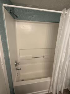 a bathroom with a tub and a shower curtain at Ocean 12 Beach Hotel in Myrtle Beach +4 photos