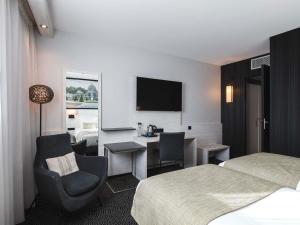 a hotel room with a bed and a chair and a desk at Hôtel Mercure Lyon Centre Charpennes Parc de la Tête d'Or in Villeurbanne