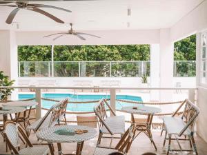 a patio with tables and chairs and a swimming pool at Novotel Wollongong Northbeach in Wollongong