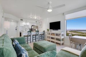 a living room with a couch and a tv and a kitchen at Lovers Key Resort 1107 in Fort Myers Beach