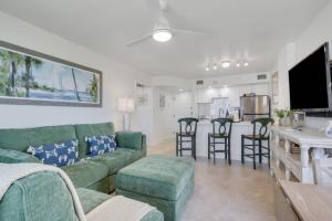a living room with a green couch and a kitchen at Lovers Key Resort 1107 in Fort Myers Beach