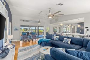 a living room with blue couches and a kitchen at Coastal Escape in Saint James City
