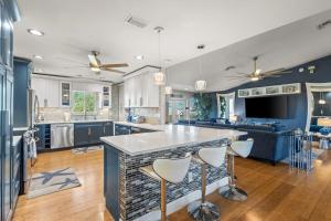 a kitchen and living room with blue cabinets and a bar at Coastal Escape in Saint James City +37 photos