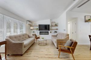 a living room with two couches and a tv at Whispering Pines in Wisconsin Dells