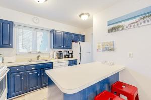 a kitchen with blue cabinets and a white refrigerator at Sea Colony --- 3404 Round Robin Way in Bethany Beach +28 photos