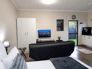 ein Wohnzimmer mit Sofa und Flachbildfernseher in der Unterkunft Scarlett's in Welgelegen