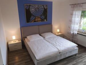 a bedroom with a bed with two night stands and a window at Appartment Schlossblick in Wiesenthau