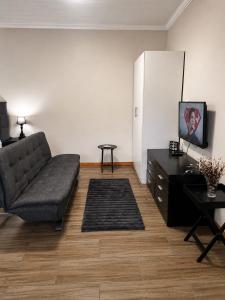 ein Wohnzimmer mit Sofa und Tisch in der Unterkunft Scarlett's in Welgelegen