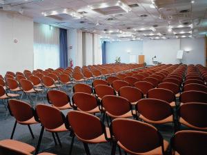 an empty room with rows of chairs in it at Novotel Firenze Nord Aeroporto in Sesto Fiorentino +120 photos