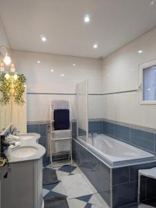 a bathroom with two sinks and a bath tub at Jardhelena in Jardin