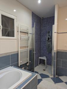 a bathroom with a tub and a window and a chair at Jardhelena in Jardin