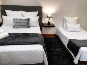 ein Schlafzimmer mit zwei Betten und weißen Kissen in der Unterkunft Scarlett's in Welgelegen