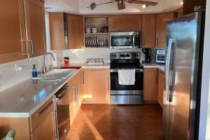 a kitchen with wooden cabinets and stainless steel appliances at Franzone Fun in Saint James City +24 photos