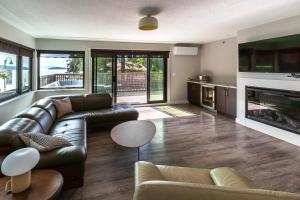 a living room with a leather couch and a fireplace at Sechelt inn in Sechelt