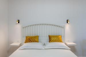 a bedroom with a white bed with two pillows at 7 Olives Luxury Suites in Rogoznica