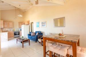 a kitchen and living room with a table and a blue couch at Oceanview Terrace, Walk to Beach, WiFi and Parking in Saint Lucy