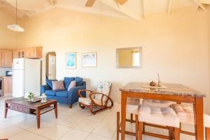 a living room with a blue couch and a table at Oceanview Terrace, Walk to Beach, WiFi and Parking in Saint Lucy