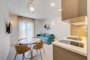 a kitchen and living room with a table and chairs at 7 Olives Luxury Suites in Rogoznica