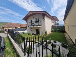 a house with a fence in front of a yard at Vilka Čachtice in Čachtice
