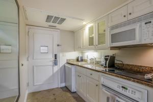 a kitchen with white cabinets and a white door at Marco Beach Ocean Resort Condominiums #605 in Marco Island