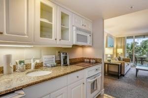 a kitchen with a sink and a living room at Marco Beach Ocean Resort Condominiums #605 in Marco Island