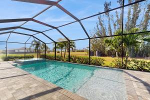a swimming pool in a house with a glass roof at Cocktail Cove in Cape Coral