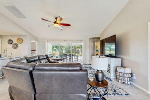 a living room with a couch and a ceiling fan at Cocktail Cove in Cape Coral