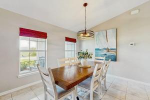 a dining room with a wooden table and chairs at Cocktail Cove in Cape Coral +13 photos