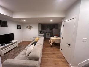 a living room with a long couch and a table at Havre de paix in Fort Saskatchewan
