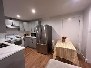 a kitchen with a table and a stainless steel refrigerator at Havre de paix in Fort Saskatchewan +25 photos