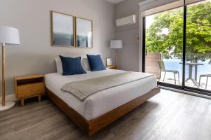a bedroom with a large bed and a large window at Sechelt inn in Sechelt