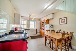 a kitchen with a table and a red refrigerator at 5 Bed in Shiskine oc-b33664 in Shiskine