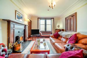a living room with a leather couch and a fireplace at 5 Bed in Shiskine oc-b33664 in Shiskine