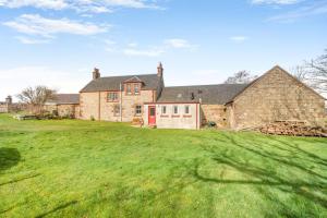 an exterior view of a large brick house with a green yard at 5 Bed in Shiskine oc-b33664 in Shiskine