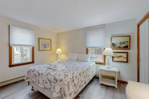 a bedroom with a bed and two lamps and windows at Skylight Tonight in South Dennis +11 photos
