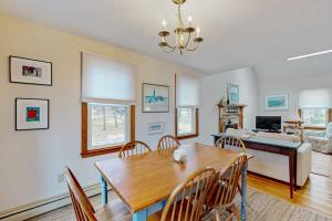 a dining room with a wooden table and chairs at Skylight Tonight in South Dennis