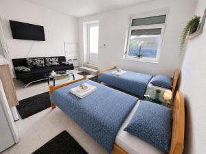 a living room with two beds and a couch at Apartmani Velić in Bugojno