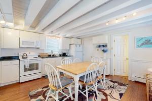 a kitchen with white cabinets and a wooden table and chairs at Oak Bluffs Cottage in Oak Bluffs