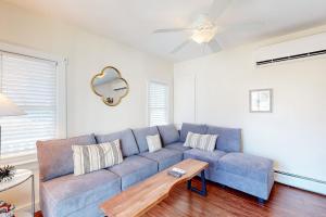 a blue couch in a living room with a table at Oak Bluffs Cottage in Oak Bluffs