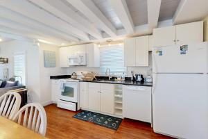 a kitchen with white cabinets and a white refrigerator at Oak Bluffs Cottage in Oak Bluffs