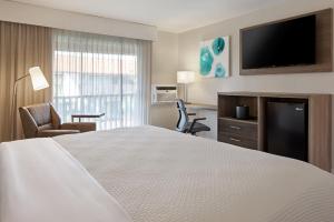 a hotel room with a bed and a flat screen tv at FOUND Hotels, Santa Barbara, Series by Marriott in Santa Barbara
