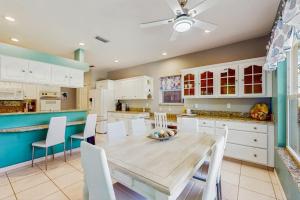 a kitchen with white cabinets and a table and chairs at Tranquil Haven in Marco Island