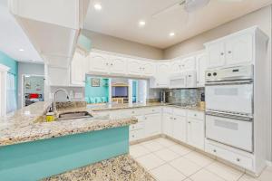 a kitchen with white cabinets and a sink at Tranquil Haven in Marco Island +21 photos
