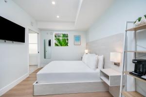 a white room with a bed and a tv at Casa Collins in Miami Beach